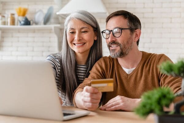 A couple looking at their computer booking a hotel.