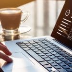 Hand on laptop touchpad with analytics dashboard on screen, symbolizing data-driven hotel revenue management strategies.